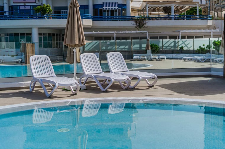 Resort-Style Pool Area with Sun Loungers and Open-Air Relaxation Space