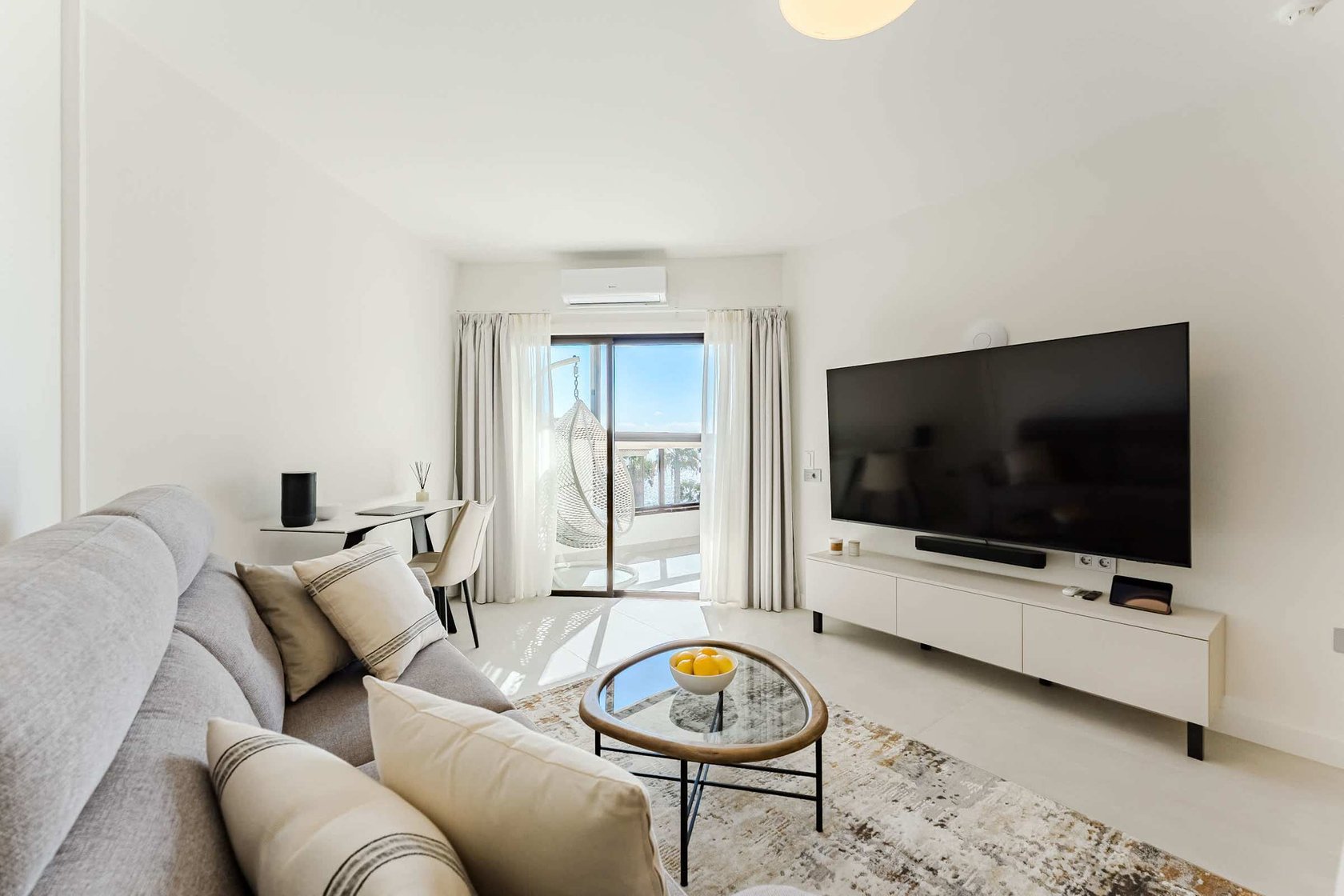 Bright Oceanfront Living Room with Designer Sofa, Oversized Flatscreen TV, Apple TV, Sonos Sound System & Elegant Workspace