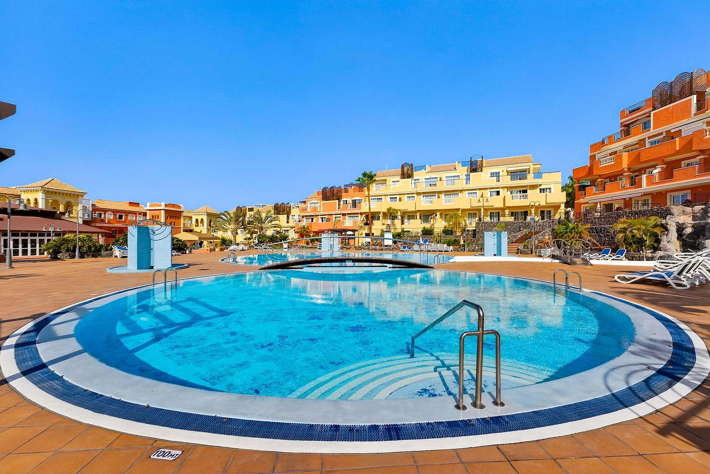 Heated Communal Swimming Pool Surrounded by Spacious Sunbathing Areas