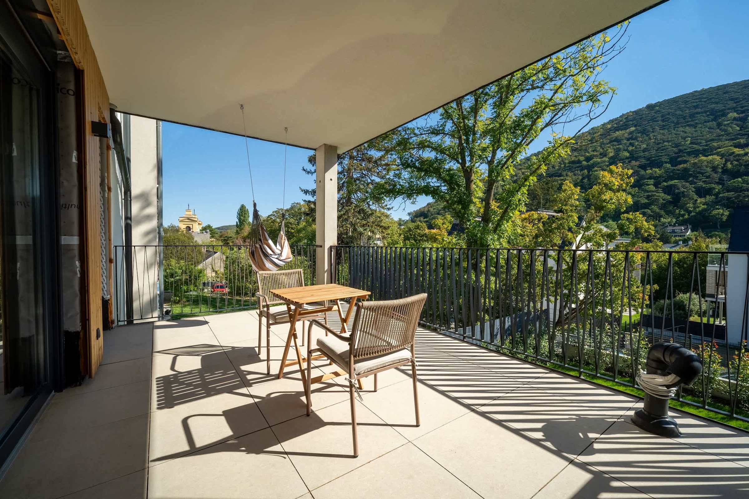 Covered balcony with outdoor dining and views of the wooded hills