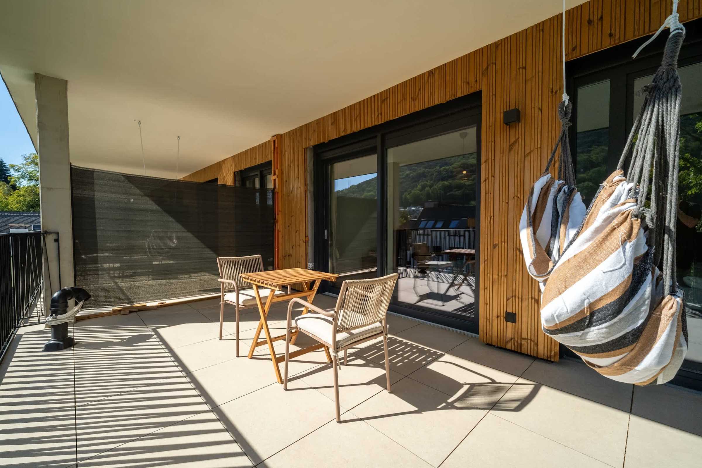 Balcony with hanging chair and outdoor dining