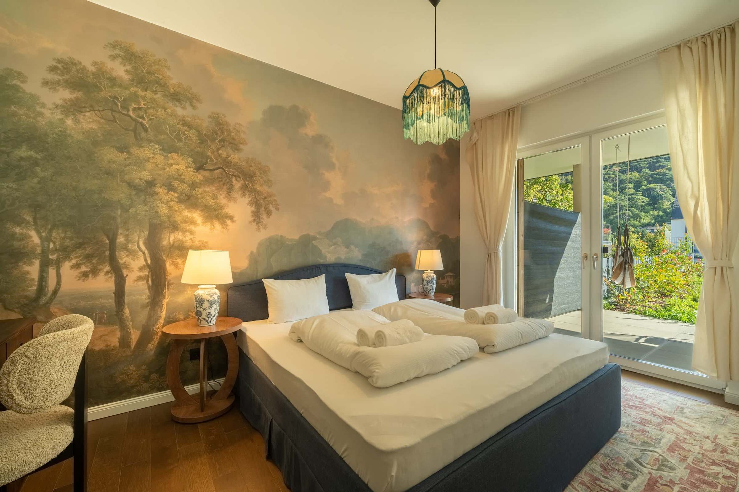 Bedroom with landscape mural and doors to the terrace
