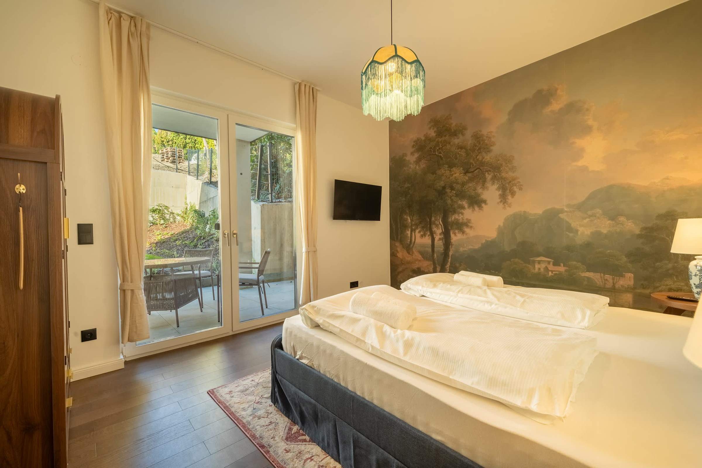 Bedroom 2 with TV and doors to the terrace