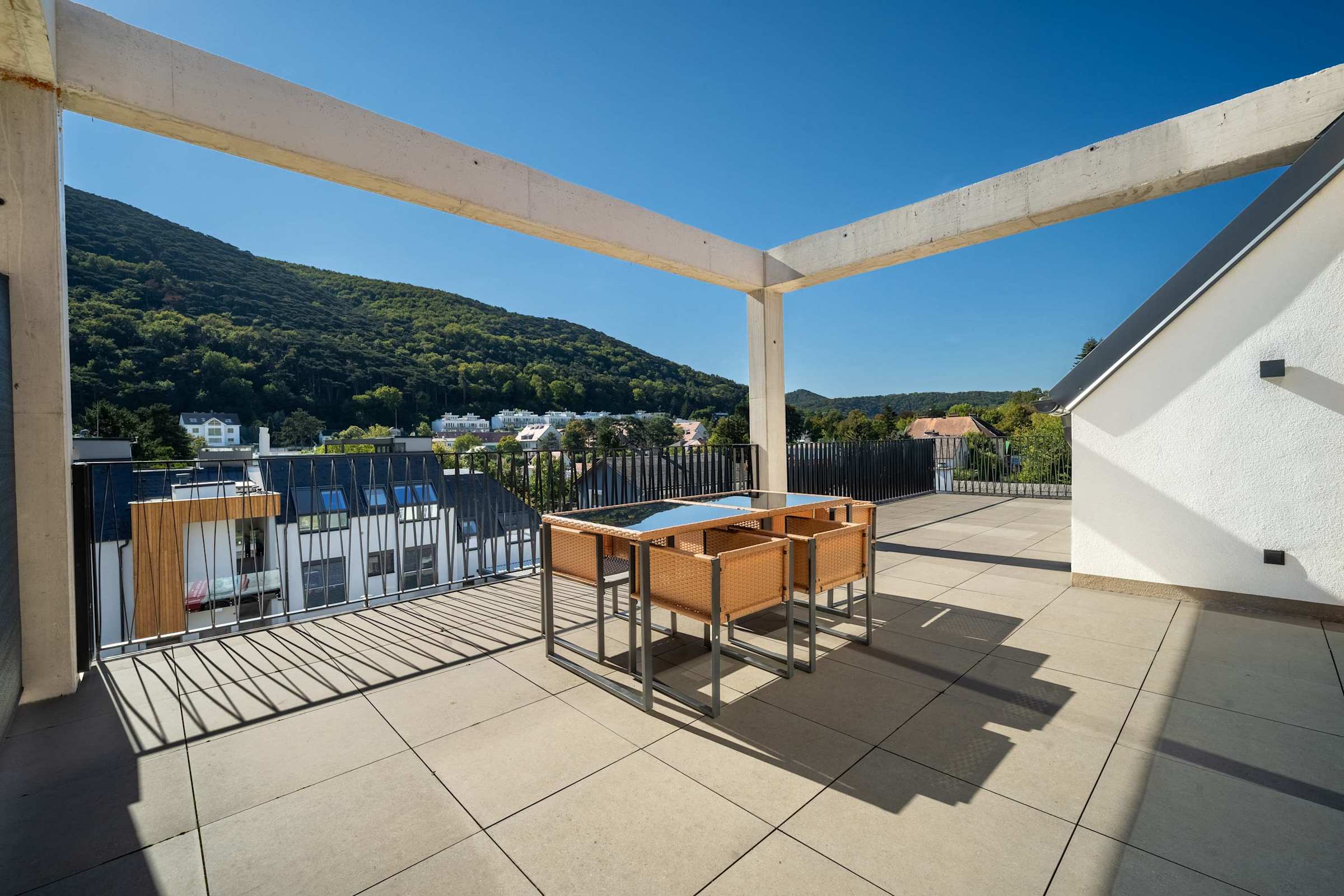 Private top-floor terrace with outdoor dining and views of the wooded hills